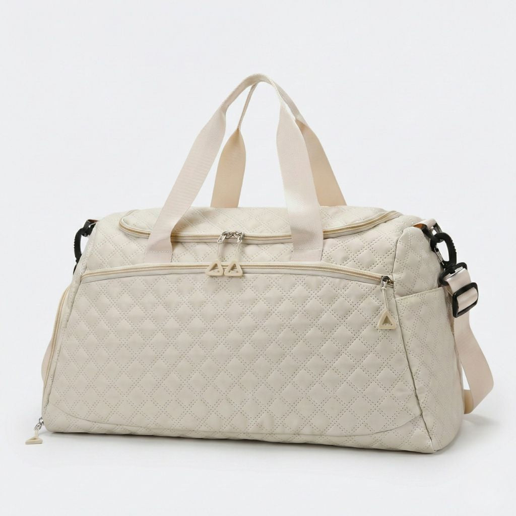 Sac weekend matelassé blanc crème ivoire vue 3/4 : motif diamants, tirettes ivoire et bandoulière réglable