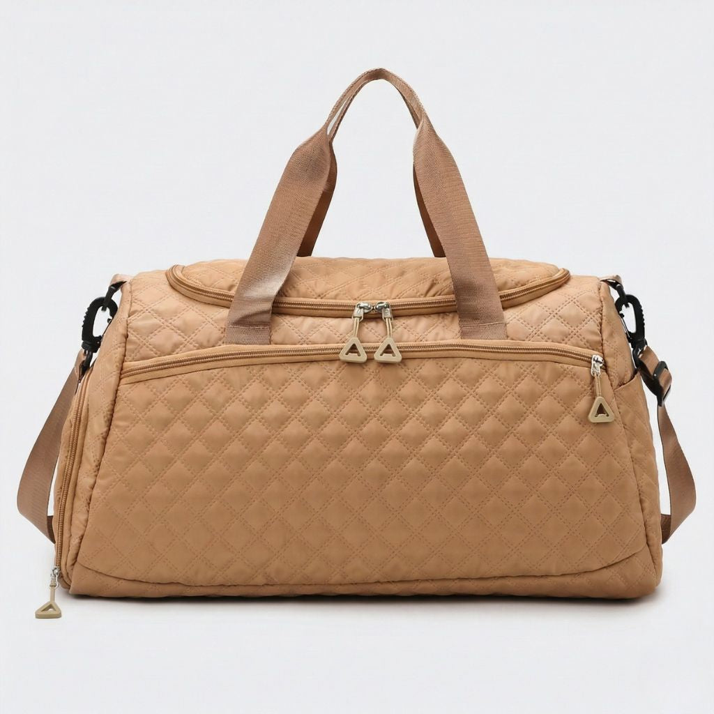 Face avant du sac weekend matelassé beige caramel avec doubles tirettes dorées, poche latérale et bandoulière