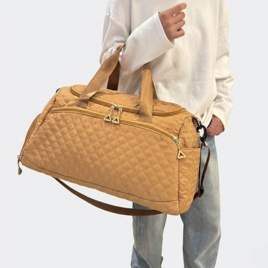 Lifestyle : personne portant le sac weekend matelassé moutarde ocre dorée à la main, style tendance