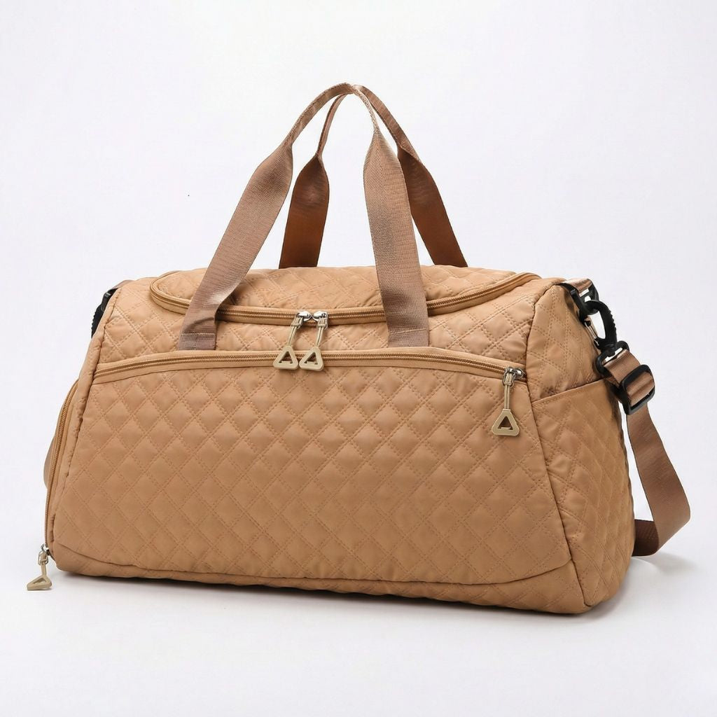 Sac weekend matelassé beige caramel vue 3/4 : tirettes dorées, poignées de portage et bandoulière