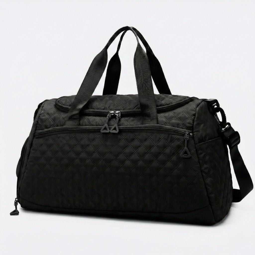 Sac weekend matelassé noir vue 3/4 avec poche latérale zippée, tirettes triangulaires et bandoulière noire