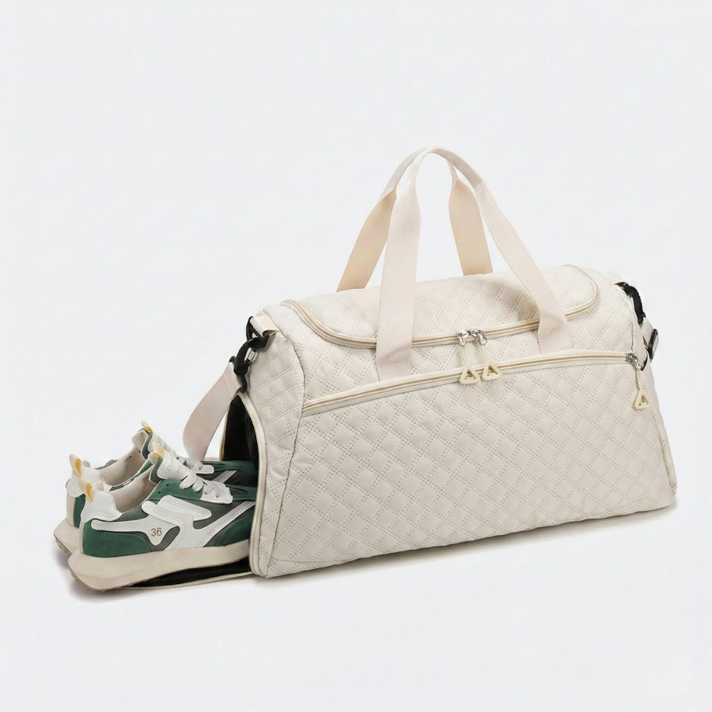 Sac de voyage matelassé beige avec compartiment chaussures ouvert sur le côté, sneakers vertes et bandoulière noire Image