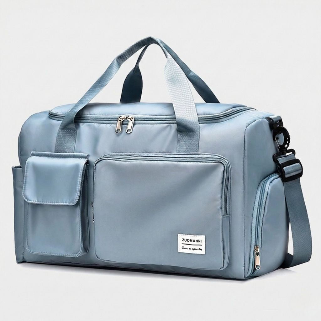 Sac de voyage femme bleu clair en nylon satiné, vue de face, poignées textiles et poche frontale zippée imperméable