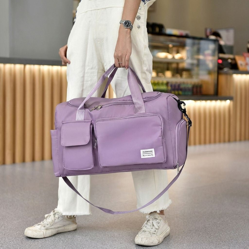 Femme tenant à bout de bras son sac de voyage cabine violet lilas en nylon dans un café lumineux et moderne