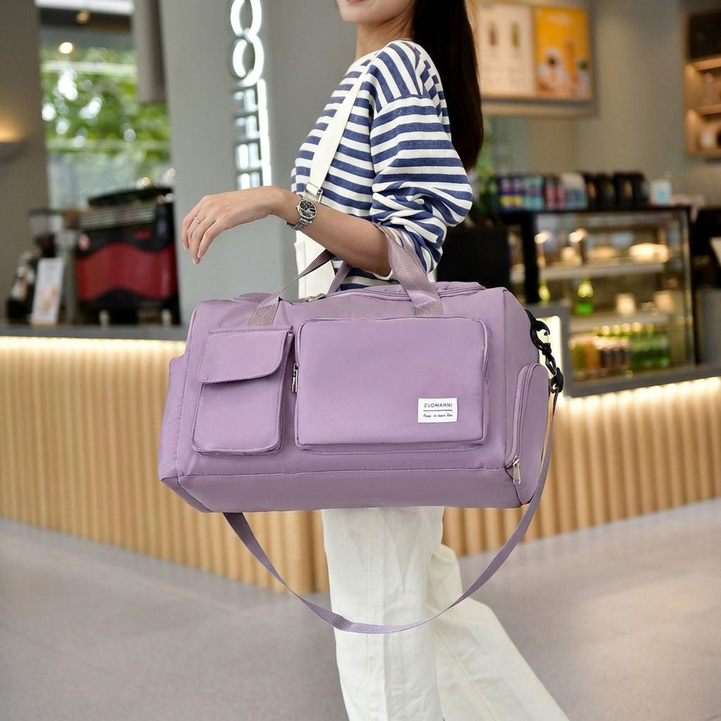Femme portant sur l'épaule un sac de voyage en nylon violet pastel avec poches frontales, dans un café Image