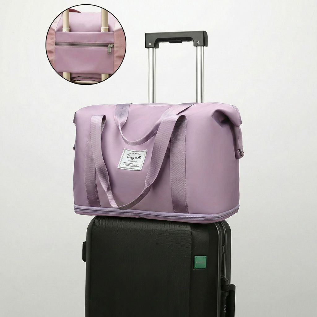 Sac de voyage femme mauve posé sur une valise noire grâce au passant trolley, avec encart zoomé sur le passant
