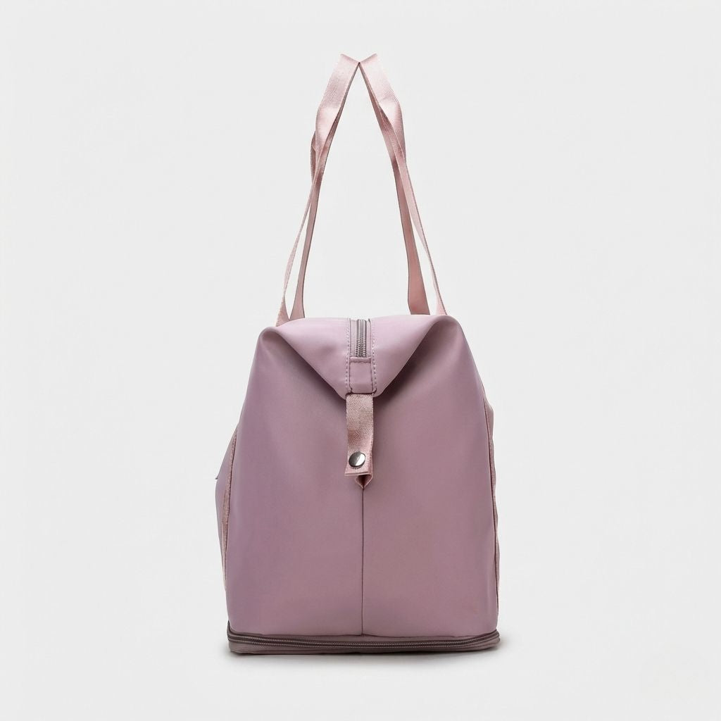 Vue arrière du sac de voyage femme rose poudré, structure cylindrique et fermeture zippée d'extension en bas