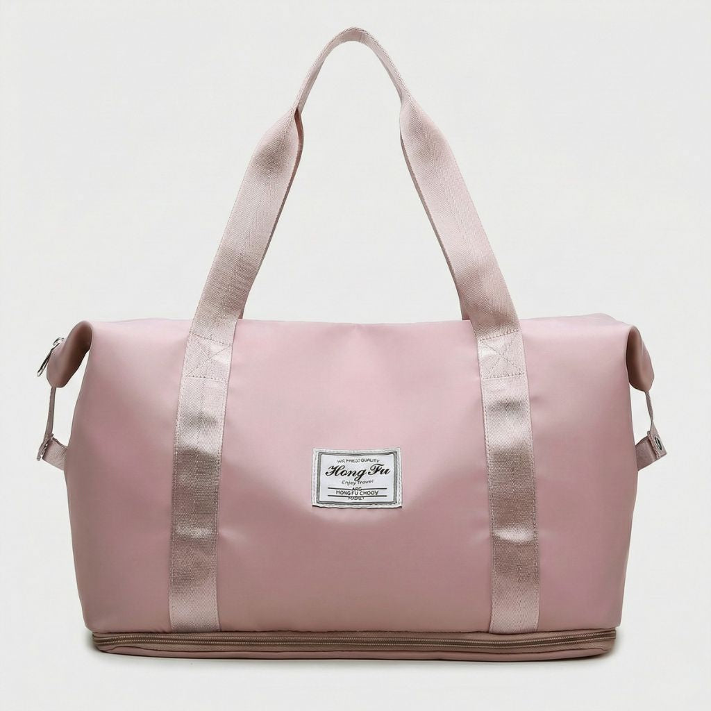 Sac de voyage femme rose clair, vue de face, poignées satinées roses et étiquette tissée, format cabine imperméable