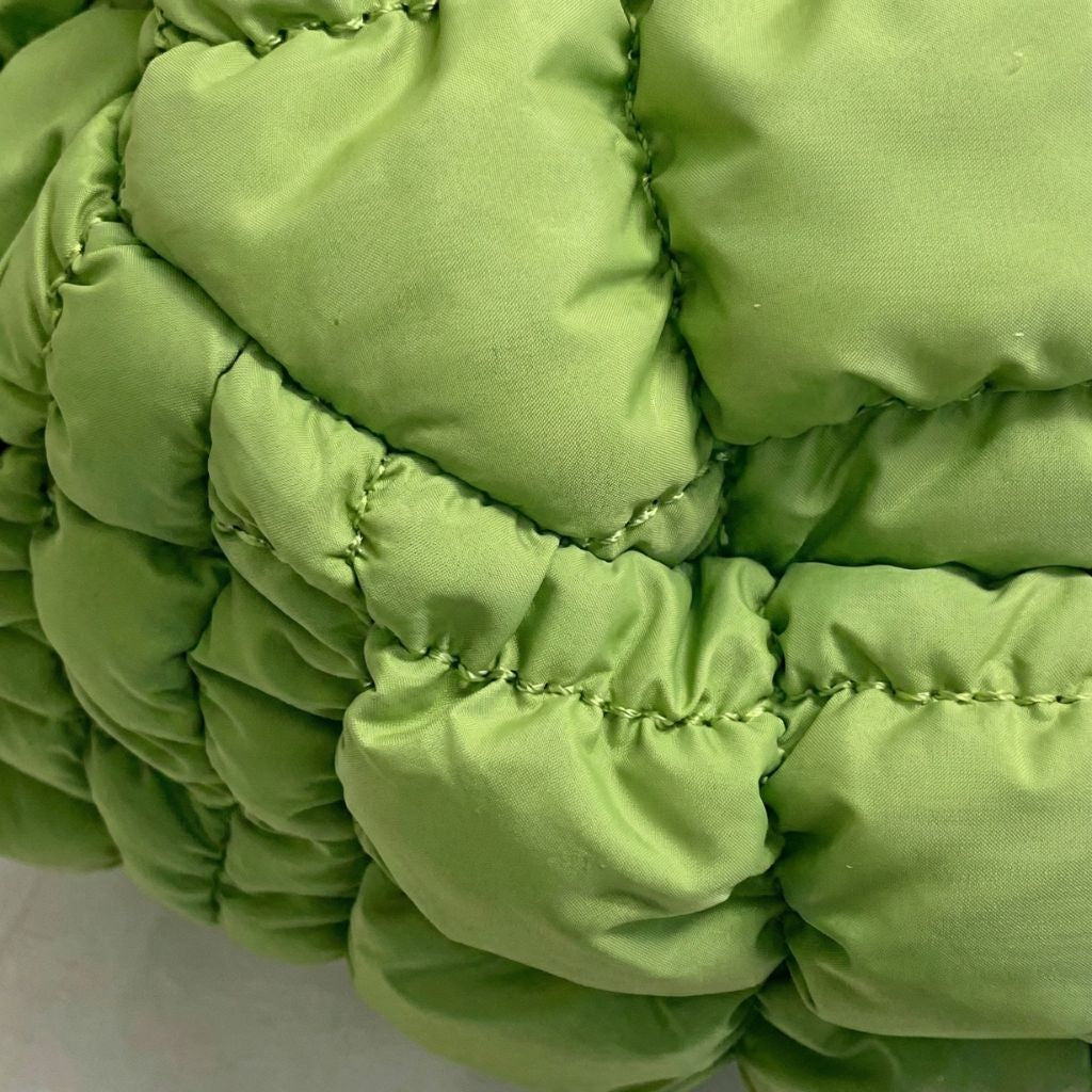 Détail de la matière nylon matelassé bulle vert anis du sac de voyage femme, texture capitonnée en relief