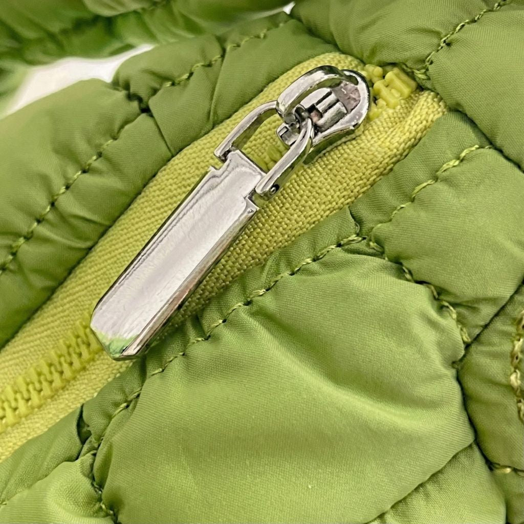 Détail de la fermeture éclair argentée du sac de voyage femme matelassé bulle vert anis, curseur métal