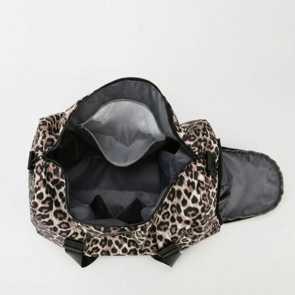Sac de voyage femme imprimé léopard blanc et gris, poignées et bandoulière noires, fermetures éclair noires