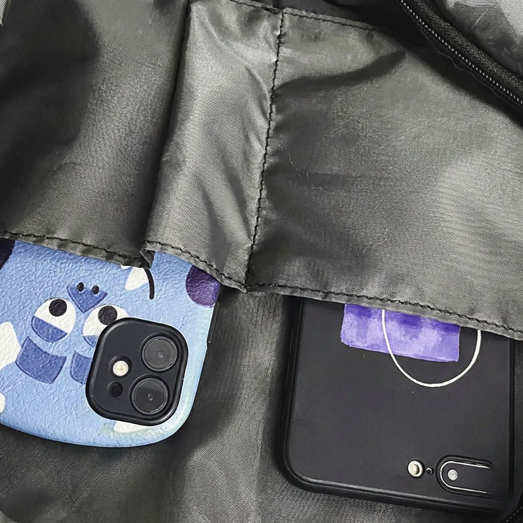 Gros plan de la poche intérieure compartimentée accueillant deux smartphones dans le sac imperméable noir