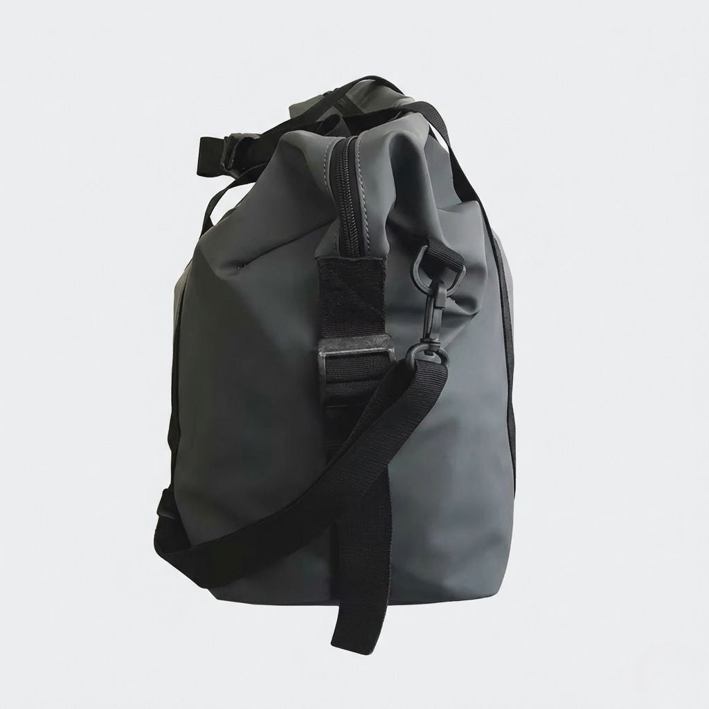 Vue de côté du sac de voyage imperméable noir graphite : fermeture latérale zippée et bandoulière réglable