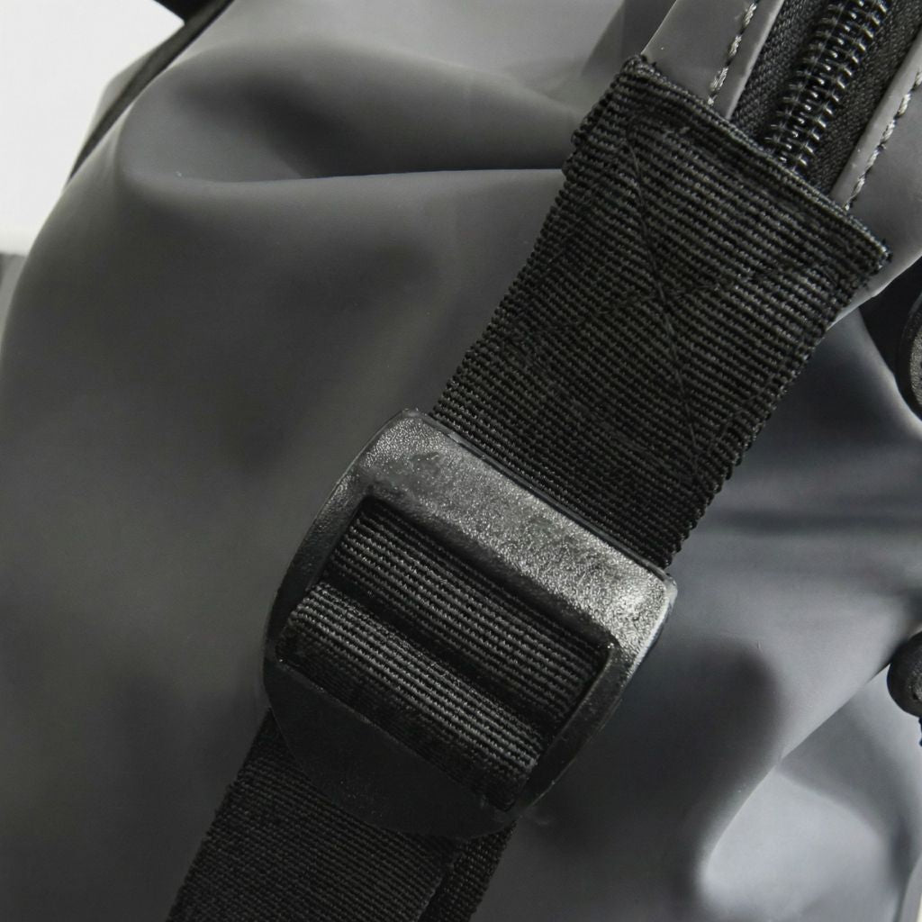 Gros plan sur la boucle de réglage en plastique noir d'un sac de week-end en nylon imperméable mat Image