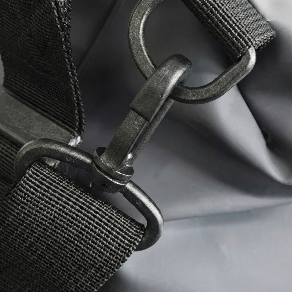 Gros plan du clip mousqueton gunmetal mat de la bandoulière du sac de voyage imperméable noir graphite