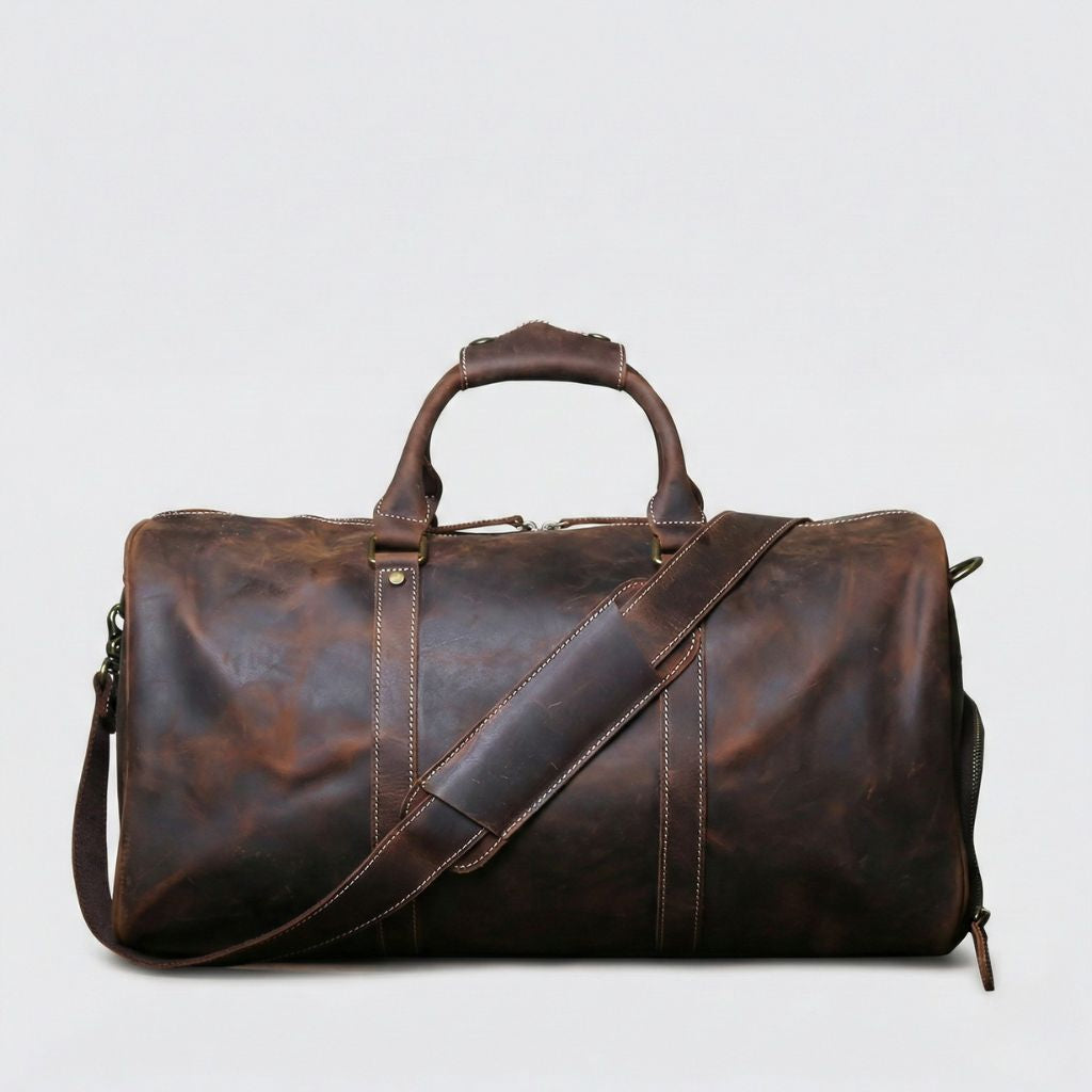 Sac week-end en cuir marron chocolat, vue de face avec bandoulière en diagonale et coutures blanches contrastées