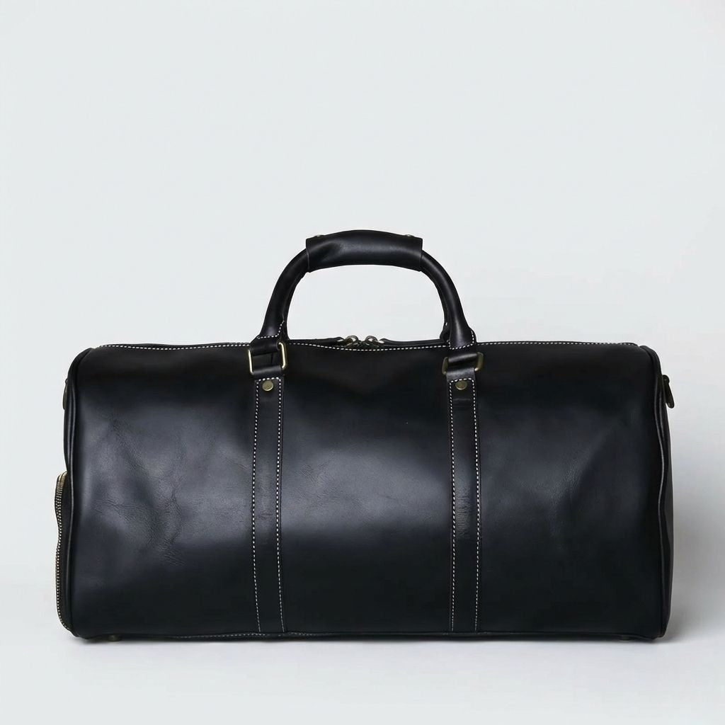 Bagage cabine en cuir noir patiné, vue de face avec coutures blanches, rivets et double poignée sans bandoulière