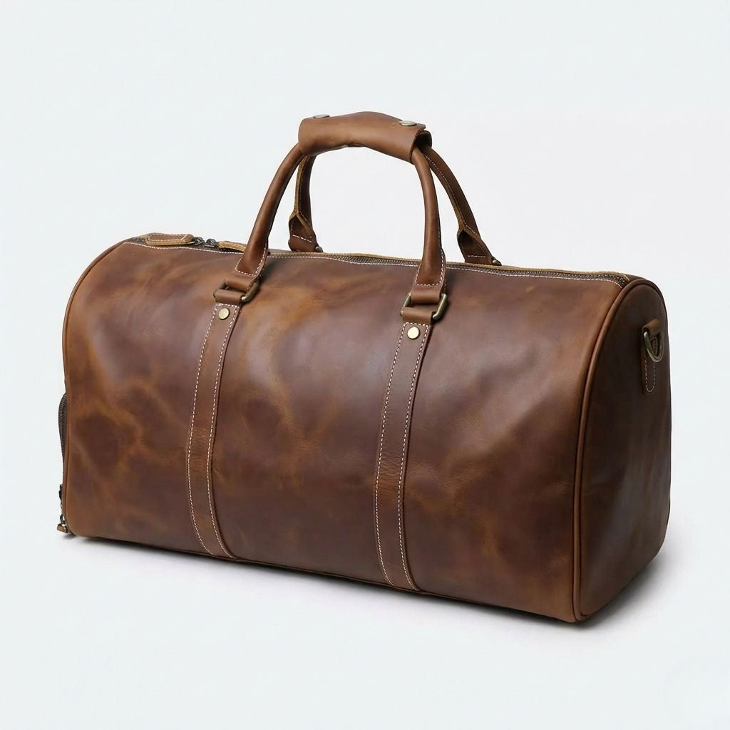 Sac polochon en cuir caramel patiné, vue trois quarts avec compartiments latéraux zippés et bandoulière réglable