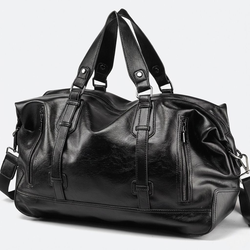 Vue trois quarts du sac de voyage noir en simili-cuir vieilli avec sangles décoratives et fermeture éclair