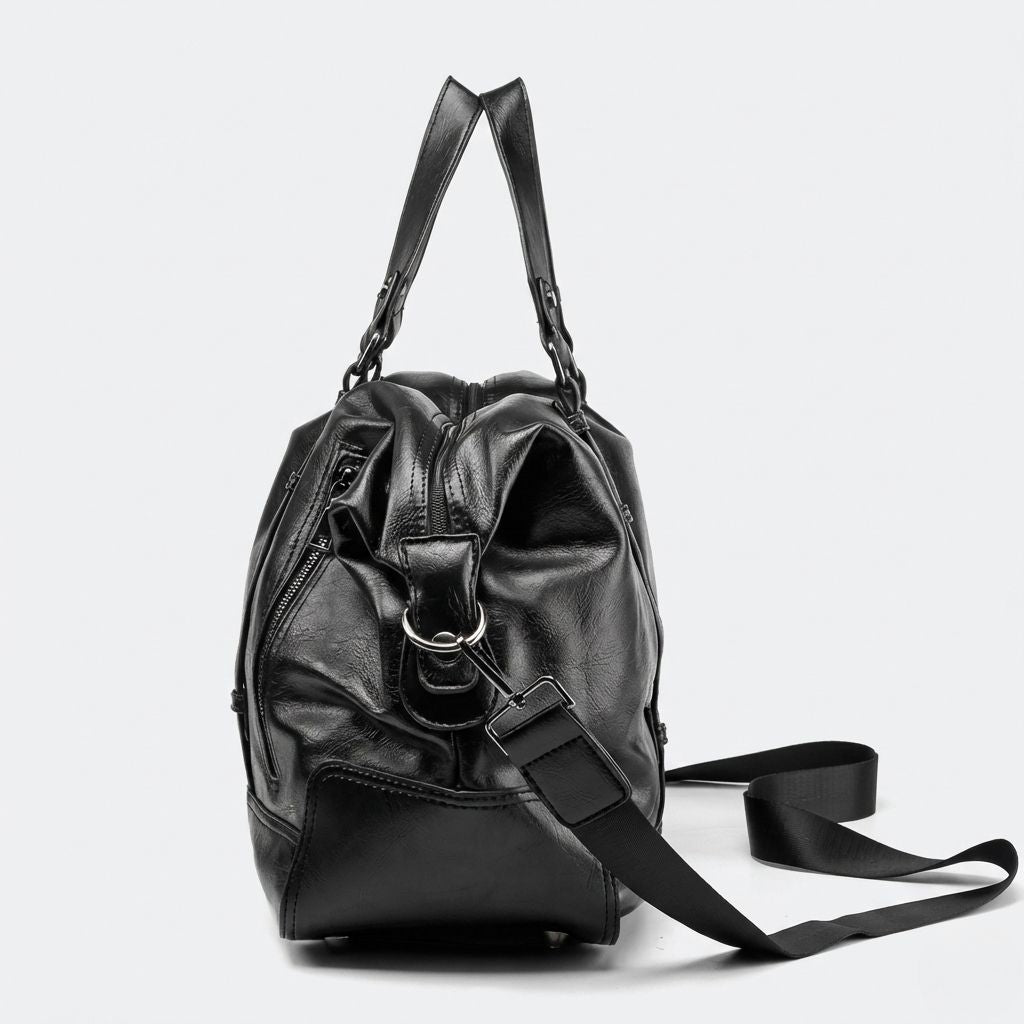 Profil latéral du sac de voyage cabine noir avec zip latéral, accroche chromée et bandoulière en sangle