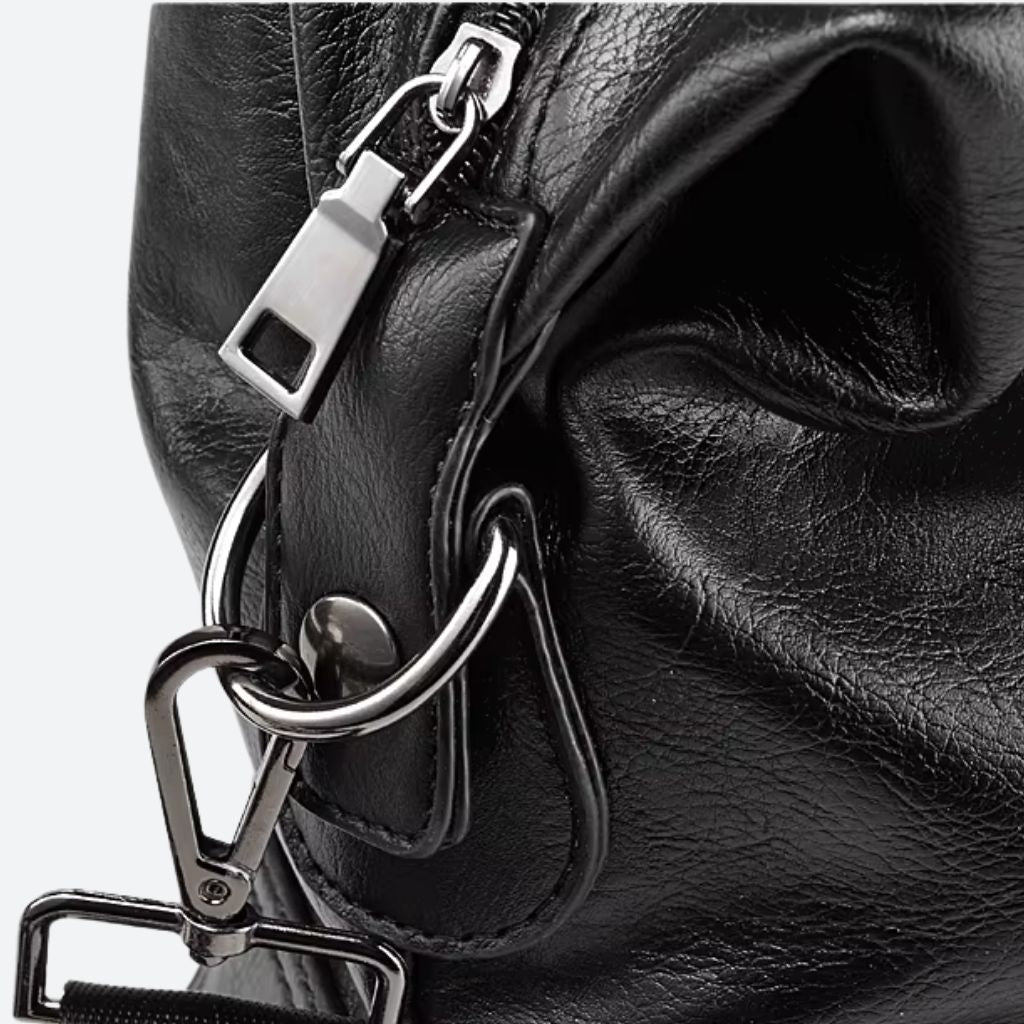 Gros plan sur la fermeture éclair et le mousqueton en métal gunmetal du sac de voyage cabine noir
