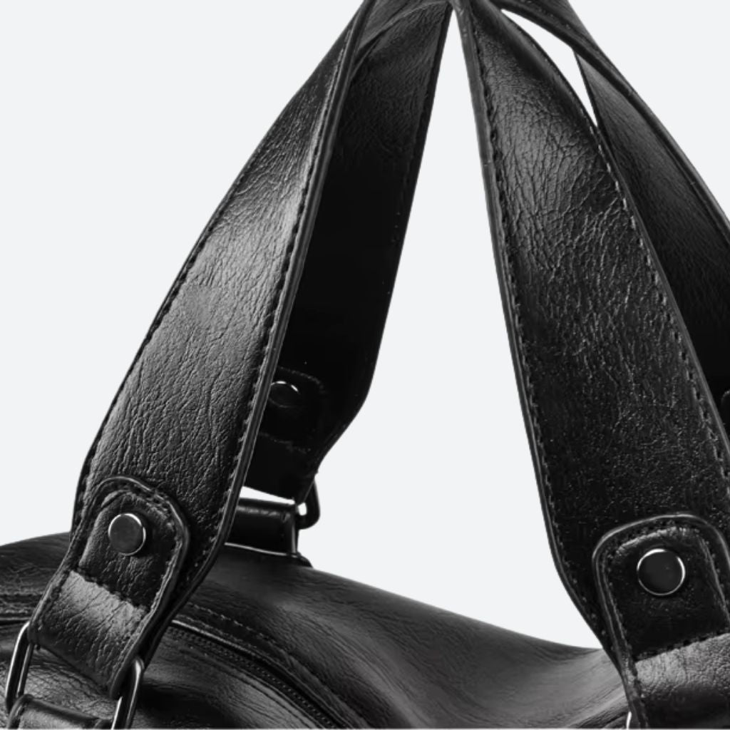 Gros plan sur les doubles poignées en simili-cuir texturé noir avec rivets de fixation apparents