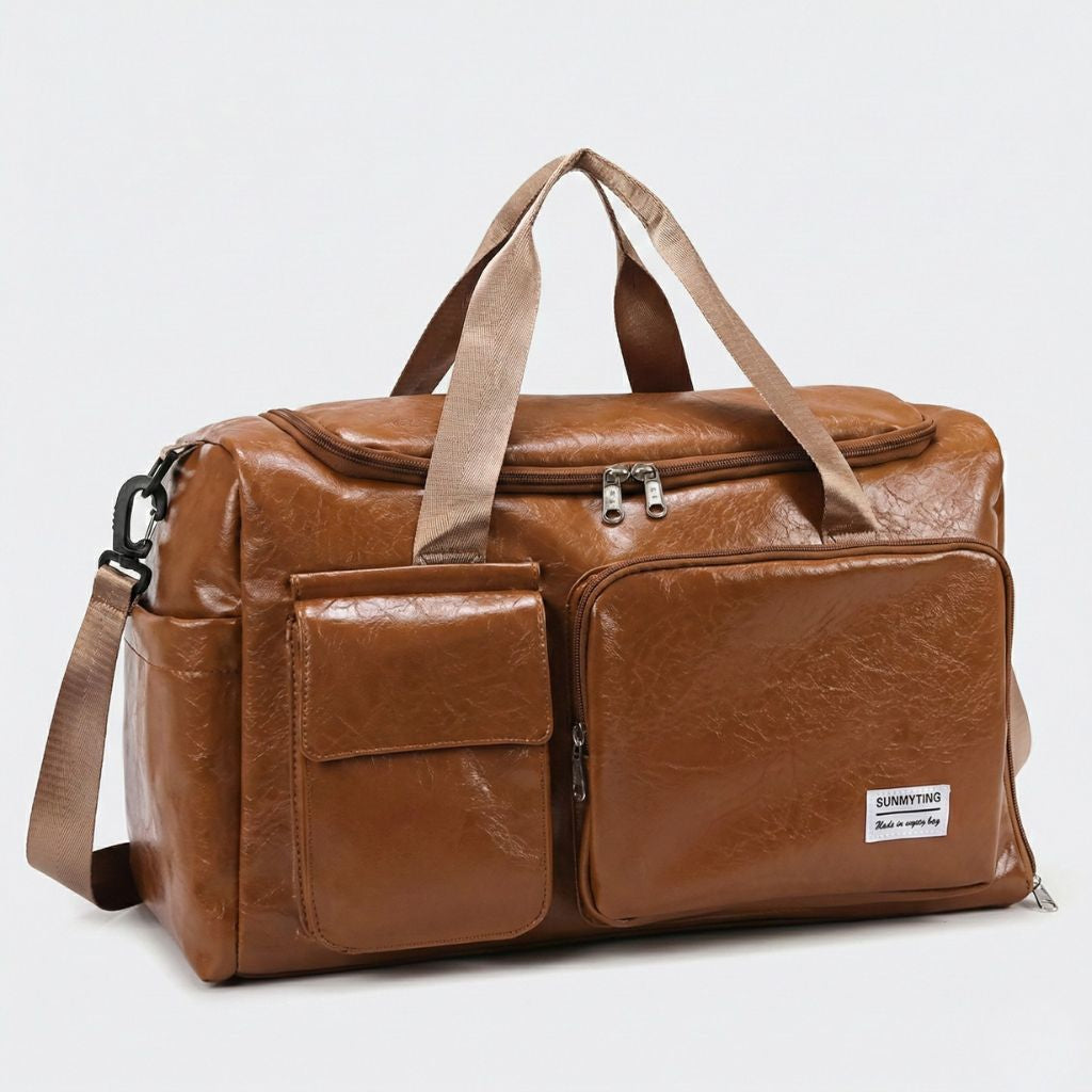 Sac cabine cognac en simili-cuir vieilli vu de trois quarts, double zip en haut et sangles beiges