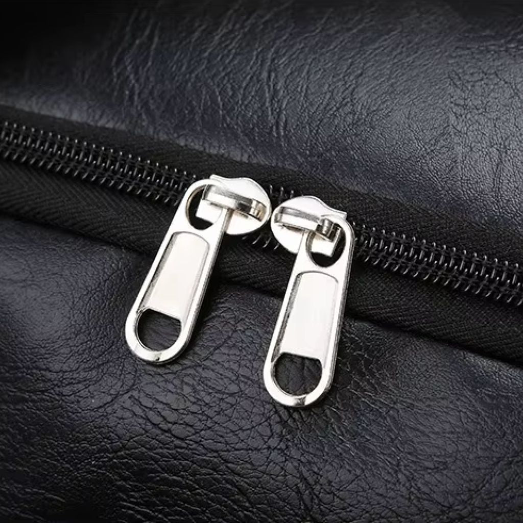 Gros plan sur les deux curseurs double en métal argenté du sac cabine noir, finition premium