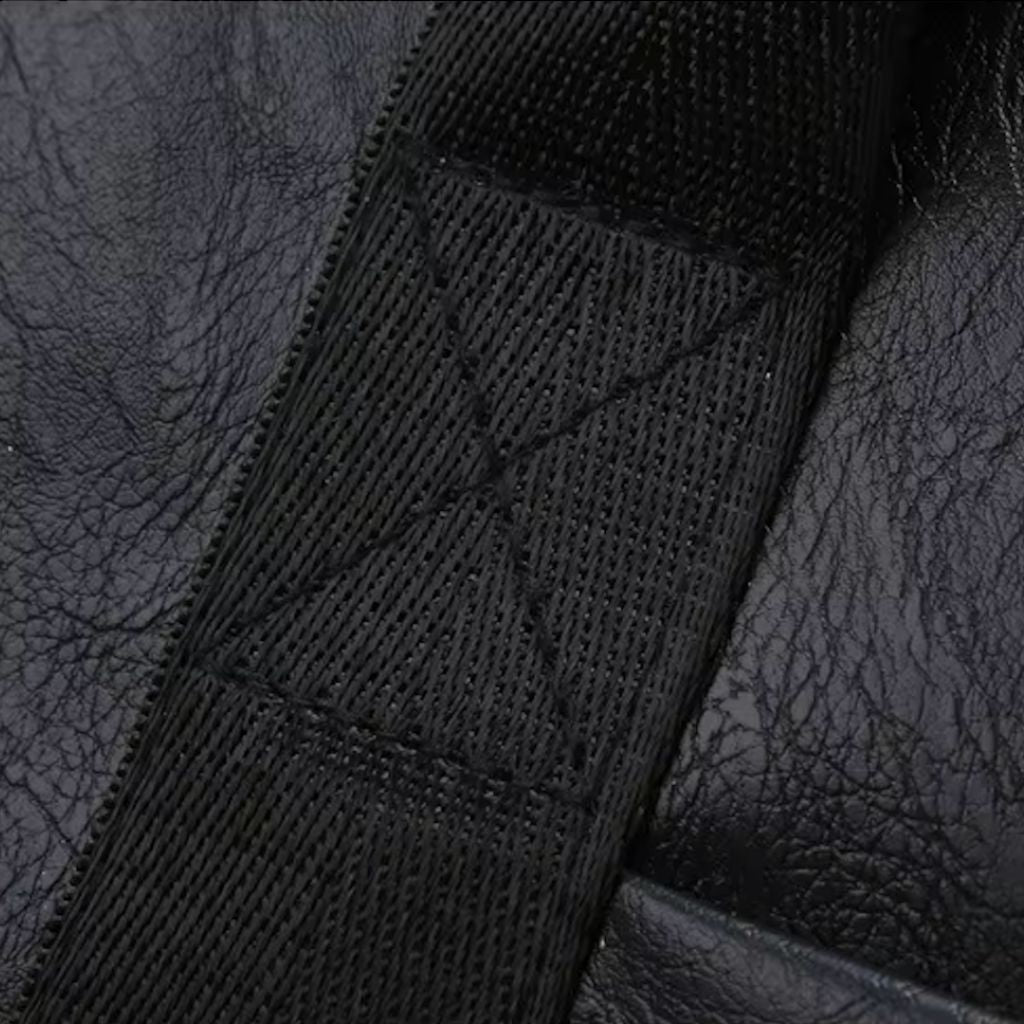 Gros plan sur la sangle textile noire matelassée et renforcée du sac de voyage cabine vintage