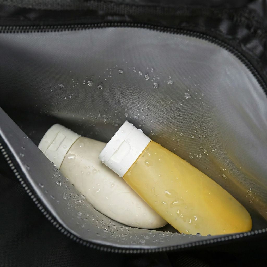 Poche latérale imperméable du sac cabine ouverte avec flacons de toilette voyage à l'intérieur