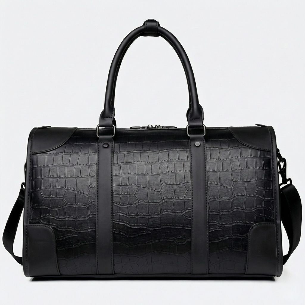 Vue de face du sac de voyage noir cabine motif croco avec renforts d'angle et bandoulière amovible noire