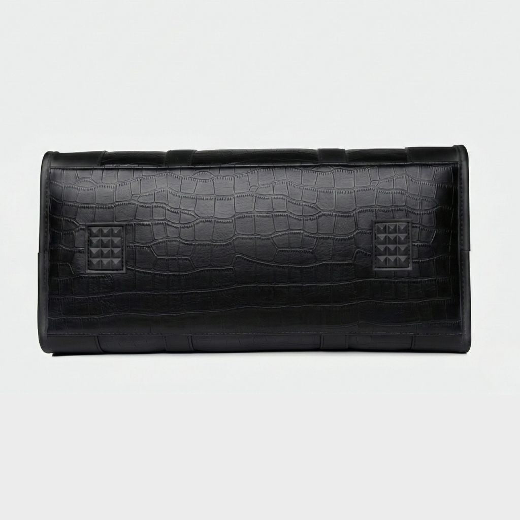 Fond plat du sac de voyage cabine noir avec motif croco et deux patins pyramidaux de protection