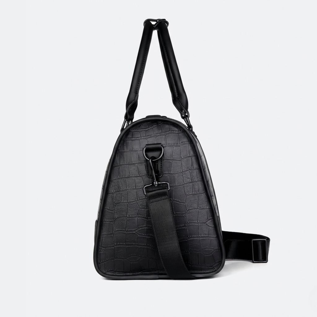 Profil latéral du sac de voyage cabine noir croco avec bandoulière en sangle textile et crochet métal